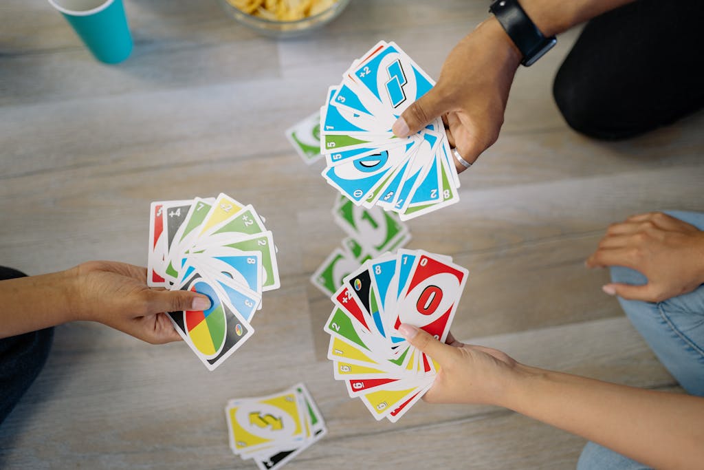 A group of friends enjoying a game of Uno, showcasing colorful cards and hands.